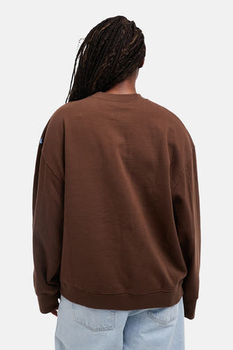 Bruine sweater met ronde hals van TOPSHOP, gezien vanaf de achterkant, gecombineerd met een lichtblauwe jeans.
