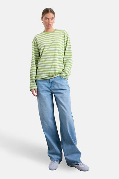 Groen gestreept T-shirt met lange mouwen van TOPSHOP, gedragen met wijde jeans en grijze sneakers.
