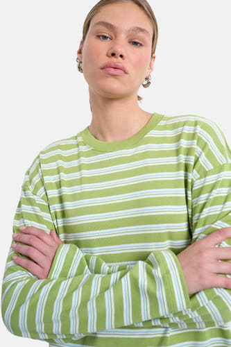 Groen T-shirt met lange mouwen van TOPSHOP, met horizontale strepen in wit en blauw, met gekruiste armen.
