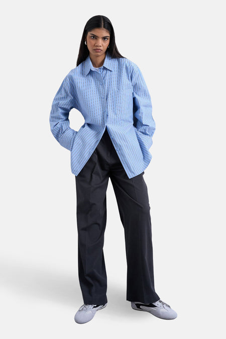 Blauw gestreept overhemd met lange mouwen van TOPSHOP, met een opengeknoopte kraag en lange, losse broek.
