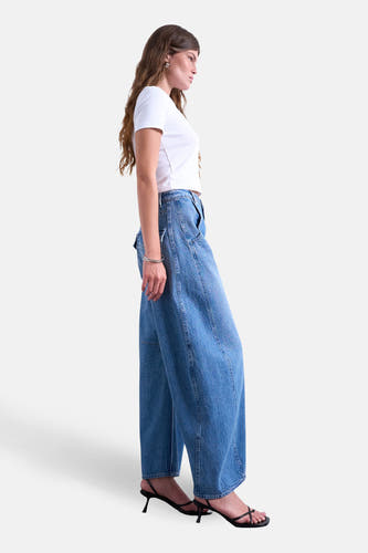 Jean spécial fit en denim bleu moyen de TOPSHOP, avec des jambes larges et porté avec un t-shirt blanc et des baskets noires.