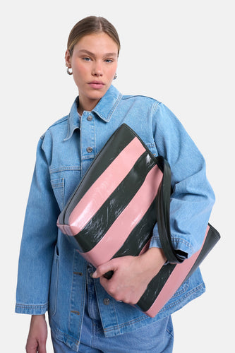 Roze schoudertas van TOPSHOP, met brede verticale zwarte strepen, gedragen bij een denim jas en jeans.