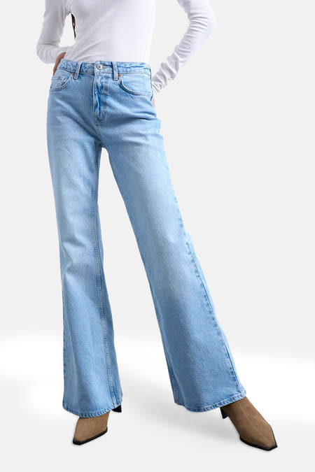 Jeans flared van lichtblauw denim van TOPSHOP, met wijde pijpen en gecombineerd met suède laarsjes.