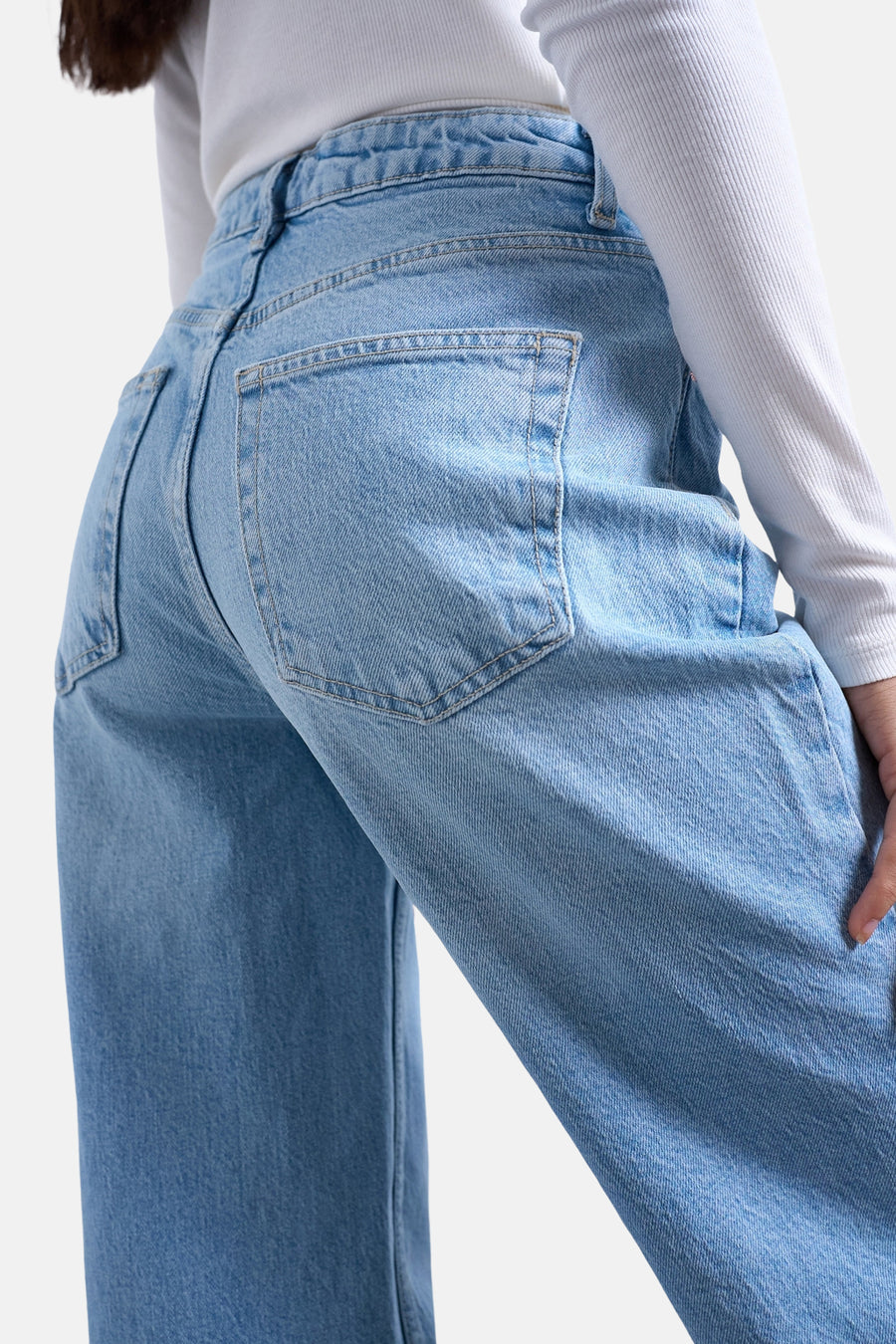Lichtblauwe denim flared jeans van TOPSHOP, achterkant gezien, met steekzakken en een wit geribd shirt.