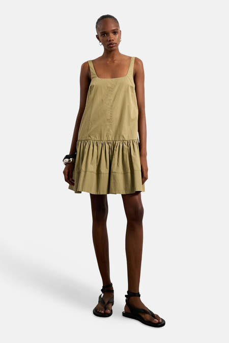 Groene mouwloze kleedje van TOPSHOP, met een gefronste rok en gedragen met zwarte sandalen.