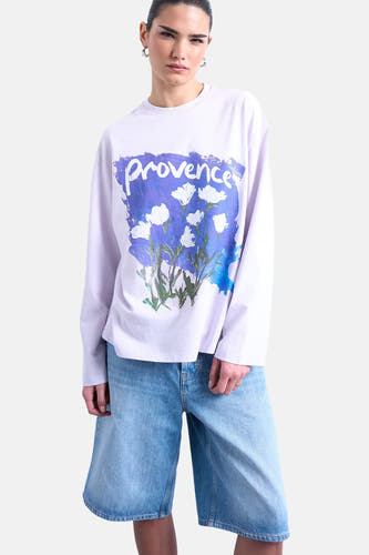 Paars T-shirt met lange mouwen van TOPSHOP, met een grafische print van bloemen en de tekst "provence", gecombineerd met denim shorts.
