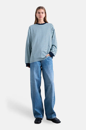 T-shirt multicolore à manches longues TOPSHOP, à rayures horizontales, associé à un jean ample et des chaussures noires.