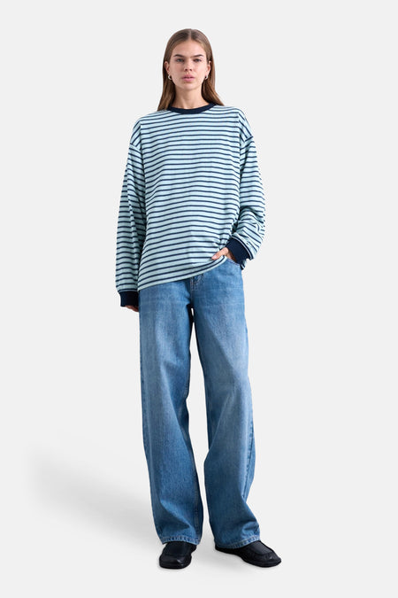T-shirt multicolore à manches longues TOPSHOP, à rayures horizontales, associé à un jean ample et des chaussures noires.