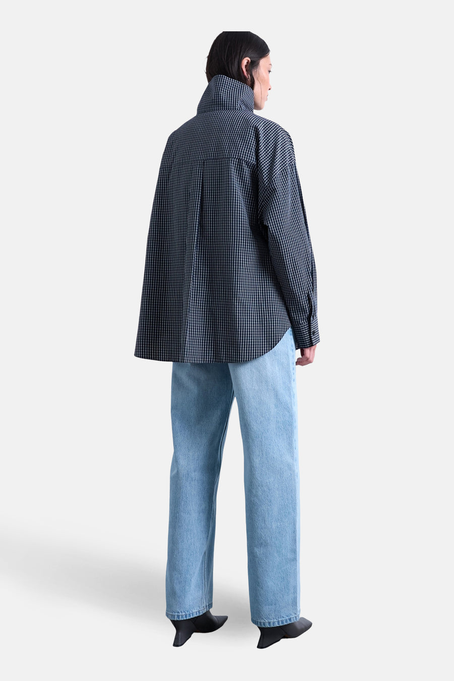 Wijde jeans van lichtblauw denim van TOPSHOP, met rechte pijpen en gecombineerd met een geruit overhemd en zwarte schoenen.
