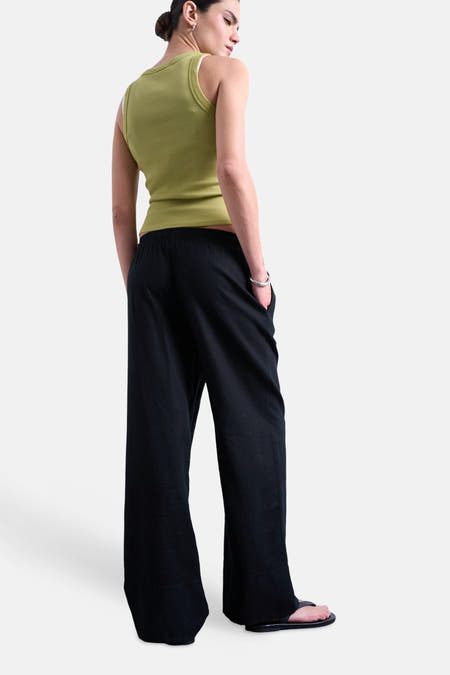 Zwarte broek van TOPSHOP, met wijde pijpen en een elastische tailleband, gezien van achteren.
