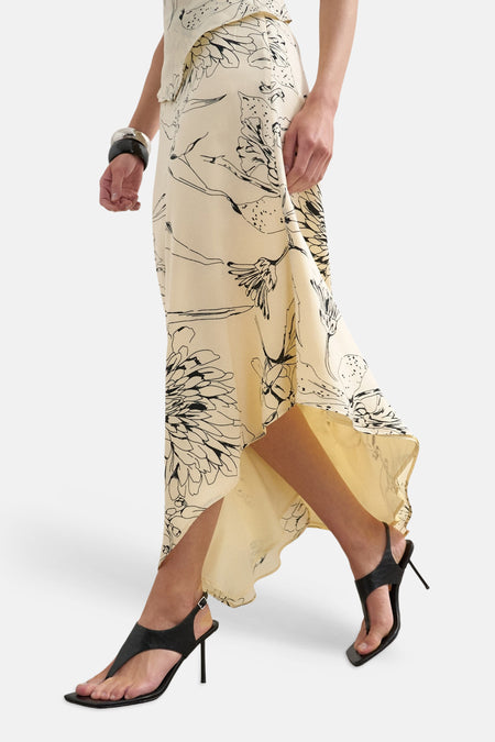 Jupe longue écru de TOPSHOP, avec un motif floral noir et un ourlet asymétrique.