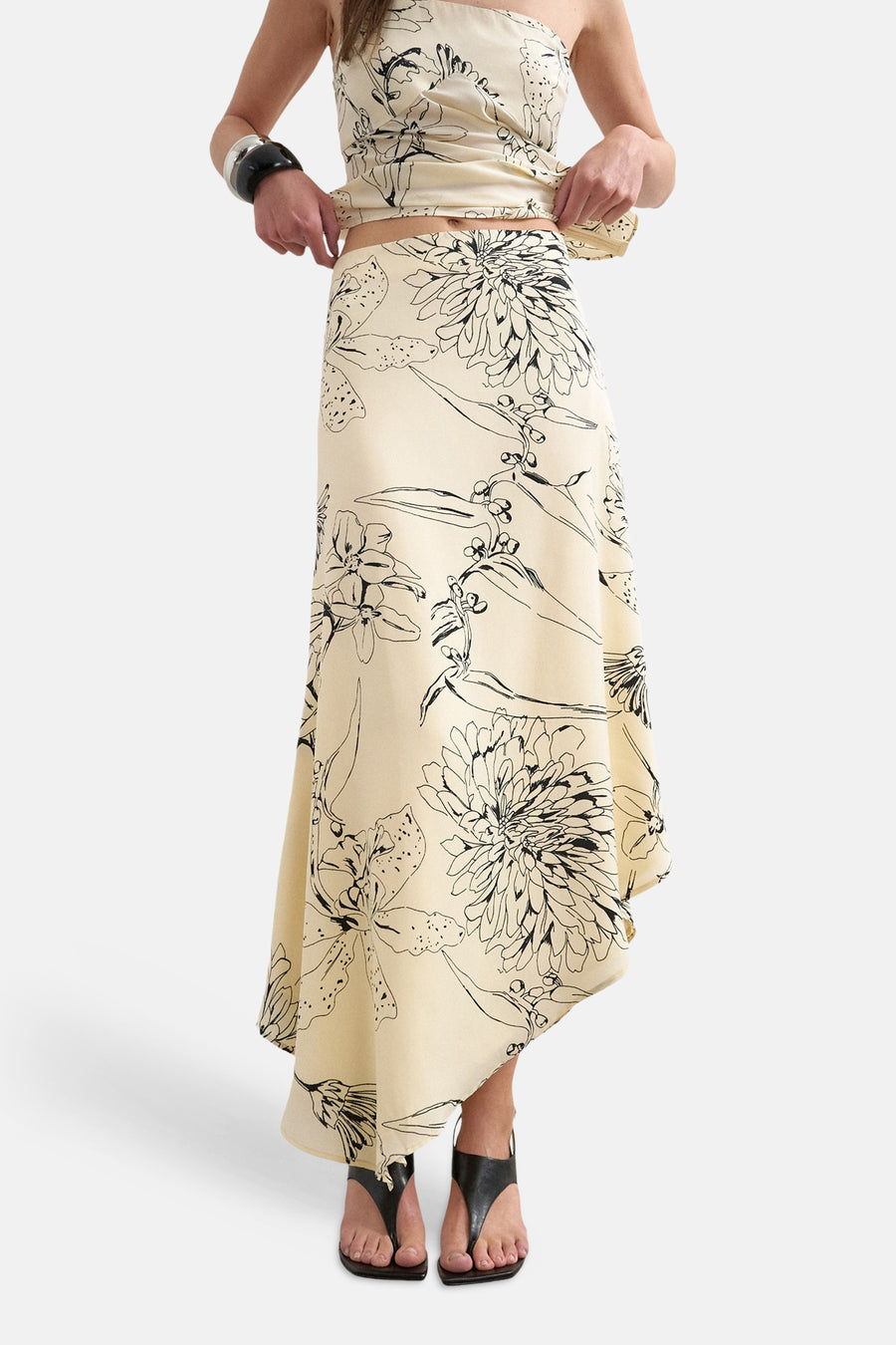 Lange ecru rok van TOPSHOP, met een zwart bloemenpatroon en asymmetrische zoom.
