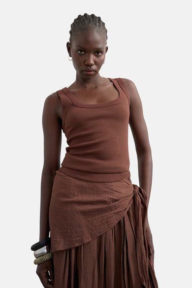 Débardeur marron de TOPSHOP, porté avec une longue jupe plissée à détail boutonné et des bracelets.