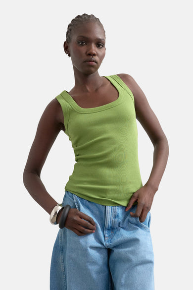Groene top van TOPSHOP, met een geribbelde textuur en vierkante halslijn, gecombineerd met wijde jeans en opvallende armbanden.
