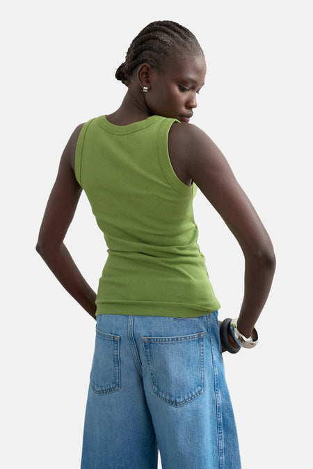Groene tanktop van TOPSHOP met ribtextuur, gedragen met denim broek en zilveren armband.