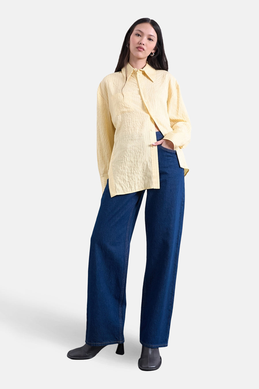 Chemise jaune à manches longues de TOPSHOP, texturée et portée avec un jean bleu et des bottes noires.