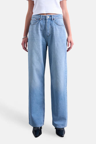 Middenblauwe straight jeans van TOPSHOP met lichte wassing, gedragen met witte crop top, zilveren armbanden en zwarte puntige schoenen.