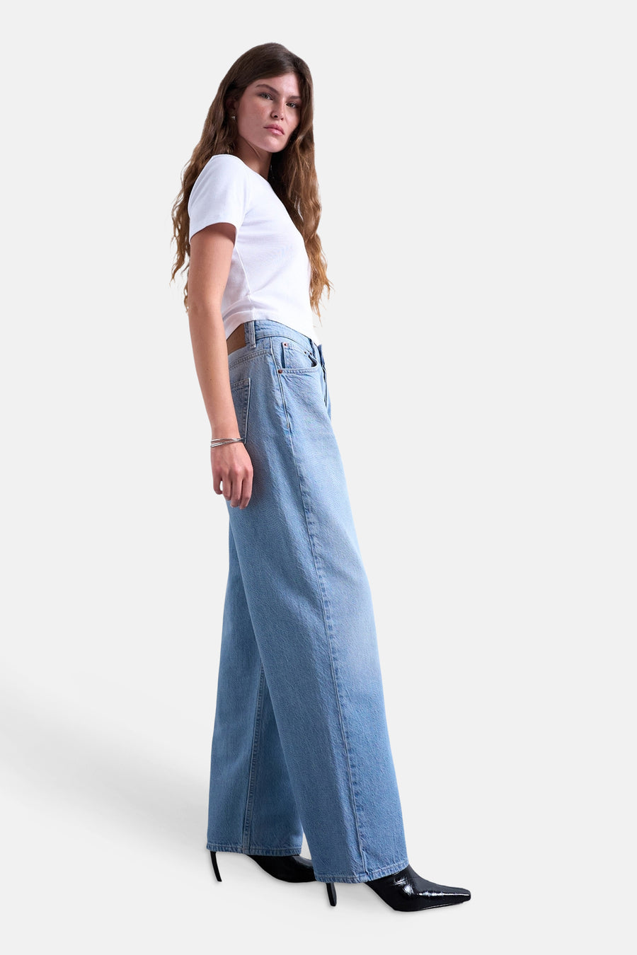 Mid-blauwe straight jeans van TOPSHOP, met wijde pijpen, gedragen door een model met een wit T-shirt en zwarte laarzen.