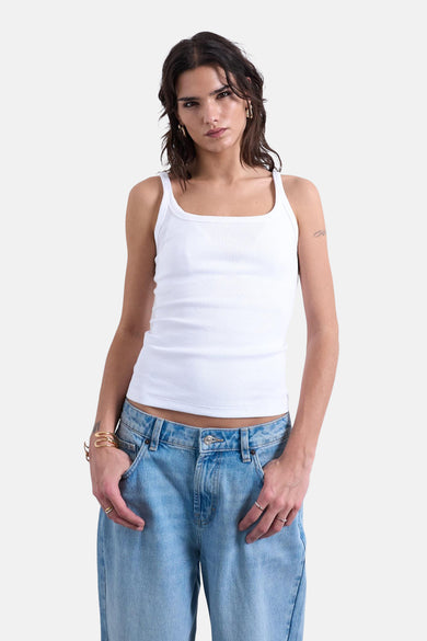 Witte top van TOPSHOP, met brede bandjes, gedragen met een losse jeans en gouden sieraden.
