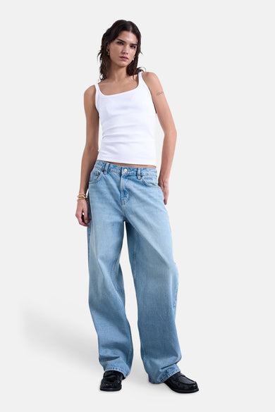 Witte tanktop van TOPSHOP, gedragen met wijde jeans en zwarte loafers.