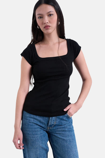 Zwart T-shirt met korte mouwen van TOPSHOP, met een vierkante halslijn, gedragen met een blauwe jeans.
