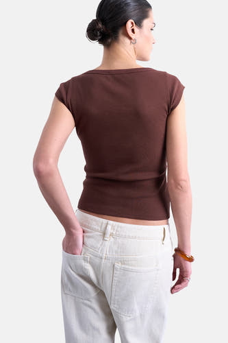 Bruin T-shirt met korte mouwen van TOPSHOP, geribbelde textuur, gedragen met een witte jeans en een bruine armband.
