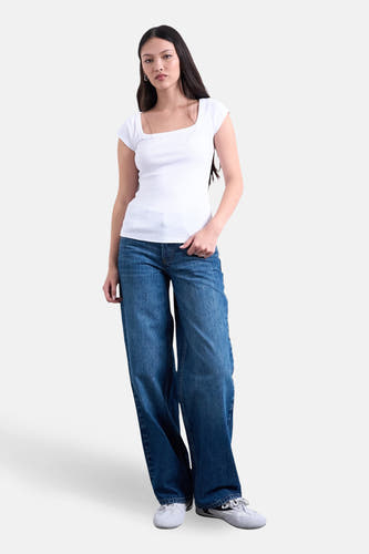 Wit T-shirt met korte mouwen van TOPSHOP, met een vierkante halslijn en gedragen met wijde jeans.
