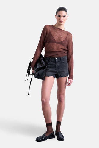 Short en jean noir de TOPSHOP, avec bords effilochés, porté avec un haut marron et des mocassins noirs avec chaussettes.