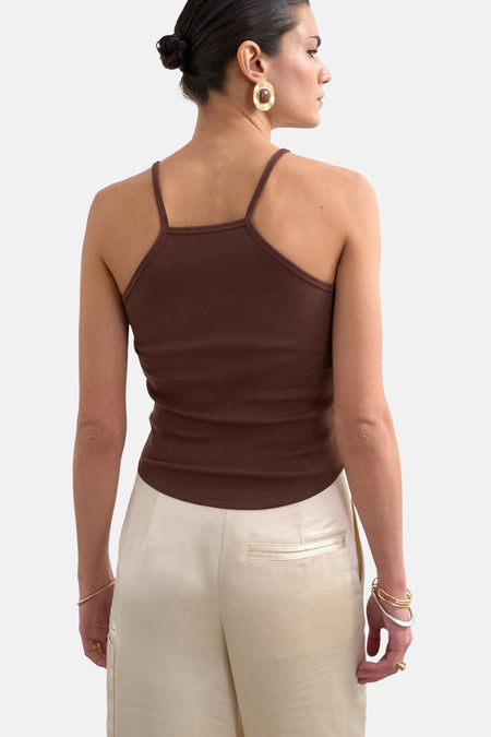 Bruine geribbelde top met spaghettibandjes van TOPSHOP, van achteren gezien op een model met lichte broek en sieraden.