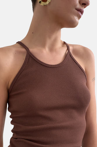 Bruine ribtop van TOPSHOP met dunne bandjes, nauwsluitend en gedragen door een model met gouden oorbel.