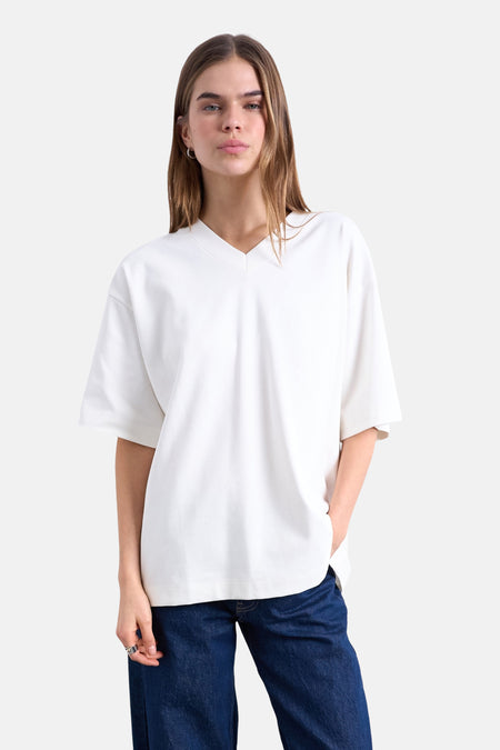 T-shirt écru de TOPSHOP avec col en V, coupe décontractée et manches courtes, porté avec un jean bleu.