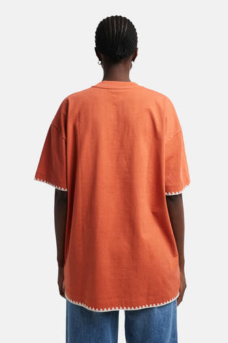 T-shirt orange à manches courtes de TOPSHOP, terminé par un bord zigzag blanc sur l'encolure et les manches, vue arrière.