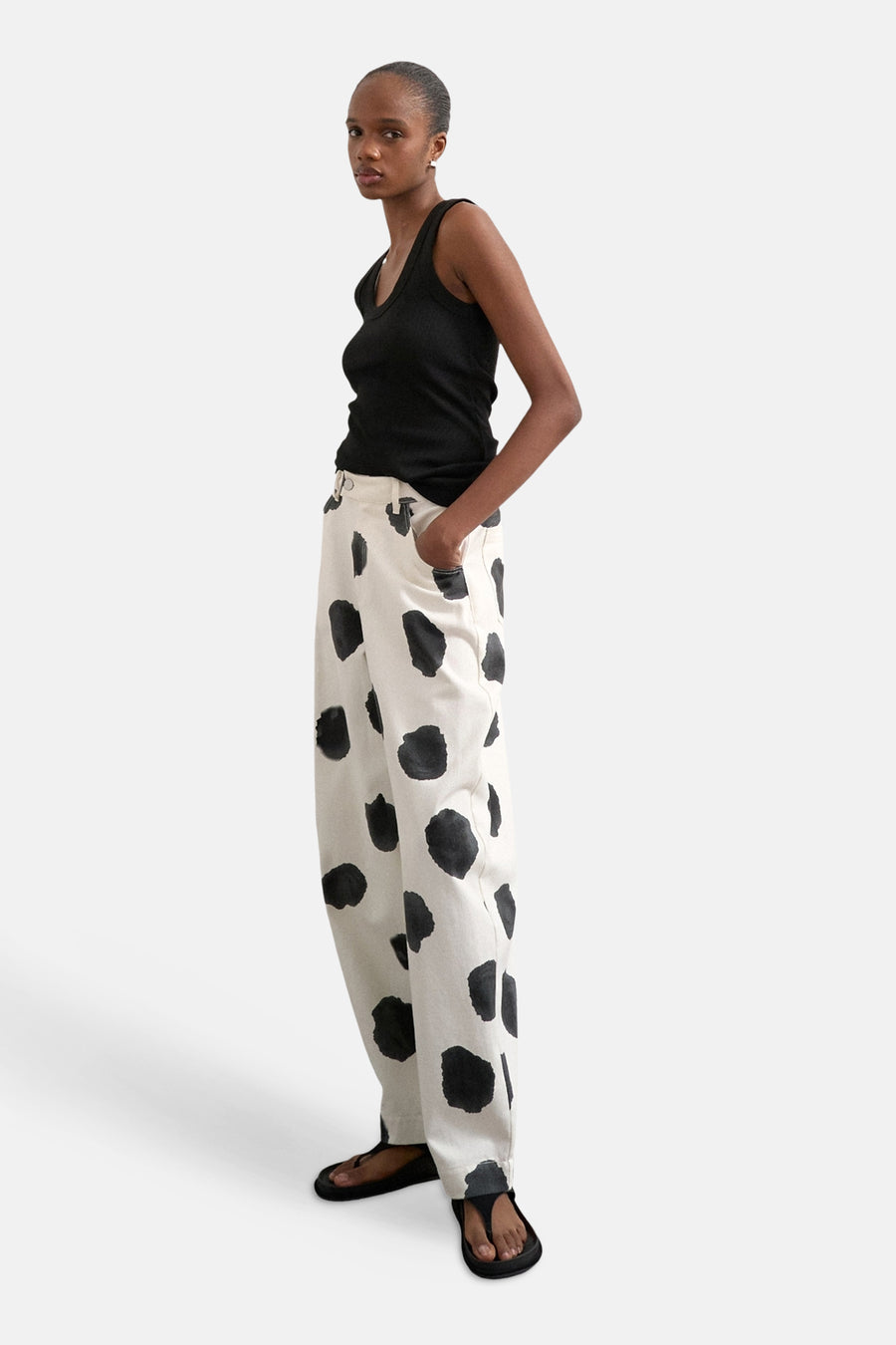 Ecru broek van TOPSHOP, met een opvallend zwart stippenpatroon, gecombineerd met een zwarte top en sandalen.