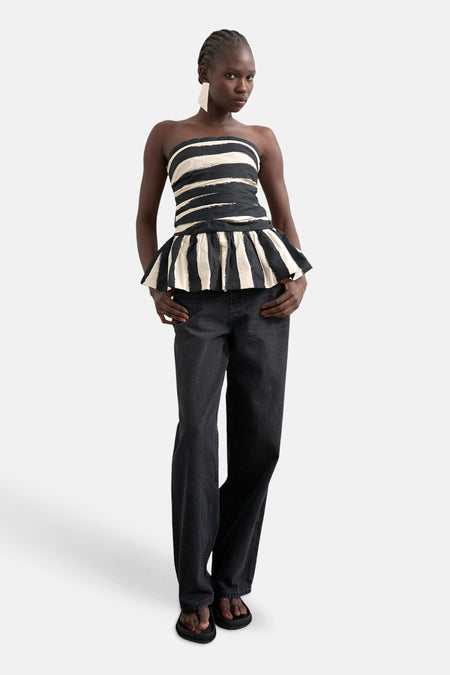 Haut bustier rayé multicolore de TOPSHOP avec larges rayures irrégulières et ourlet péplum, porté avec un jean.