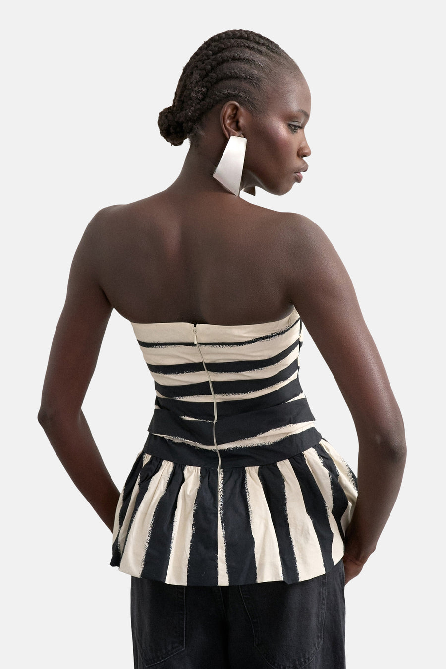 Haut bustier rayé noir et blanc de TOPSHOP avec ourlet péplum et fermeture éclair au dos, porté par un mannequin.