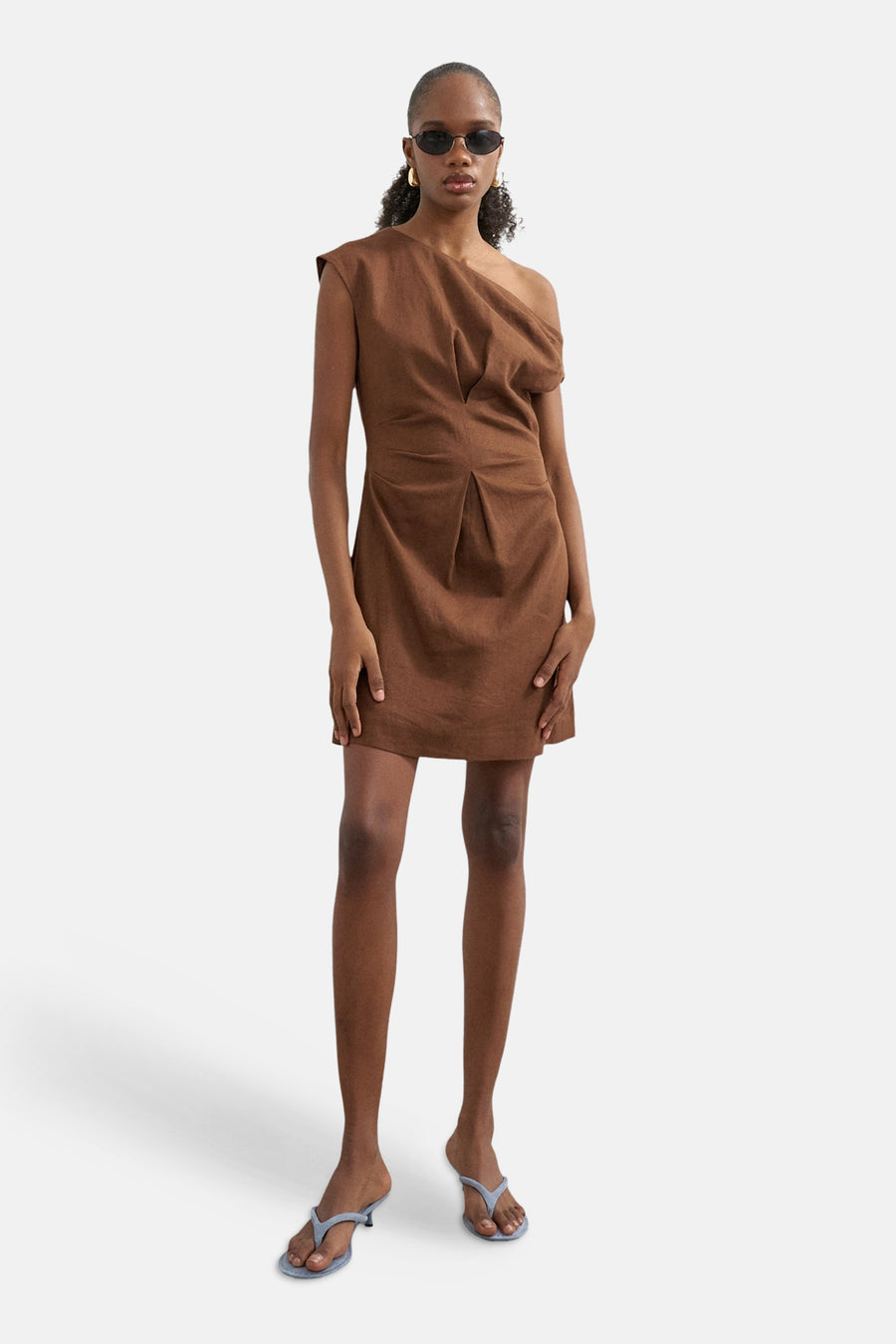 Bruin één-schouder mini-kleedje van TOPSHOP met gedrapeerde en geplooide voorkant, gedragen door een model met zonnebril en lichtblauwe hakken.
