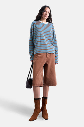 T-shirt bleu à manches longues de TOPSHOP, avec des rayures marron horizontales, combiné avec un pantalon et des bottes marron.