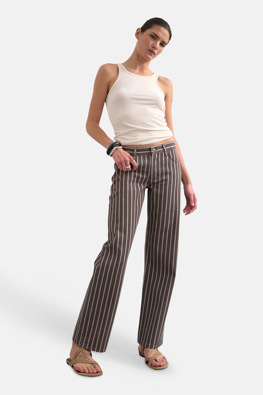 Bruine gestreepte broek van TOPSHOP, gedragen door een model met een crèmekleurige tanktop en sandalen.