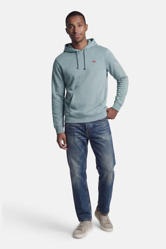 Blauwe sweater met kap van Levi's, met trekkoorden en een buidelzak, gecombineerd met blauwe jeans en grijze sneakers.