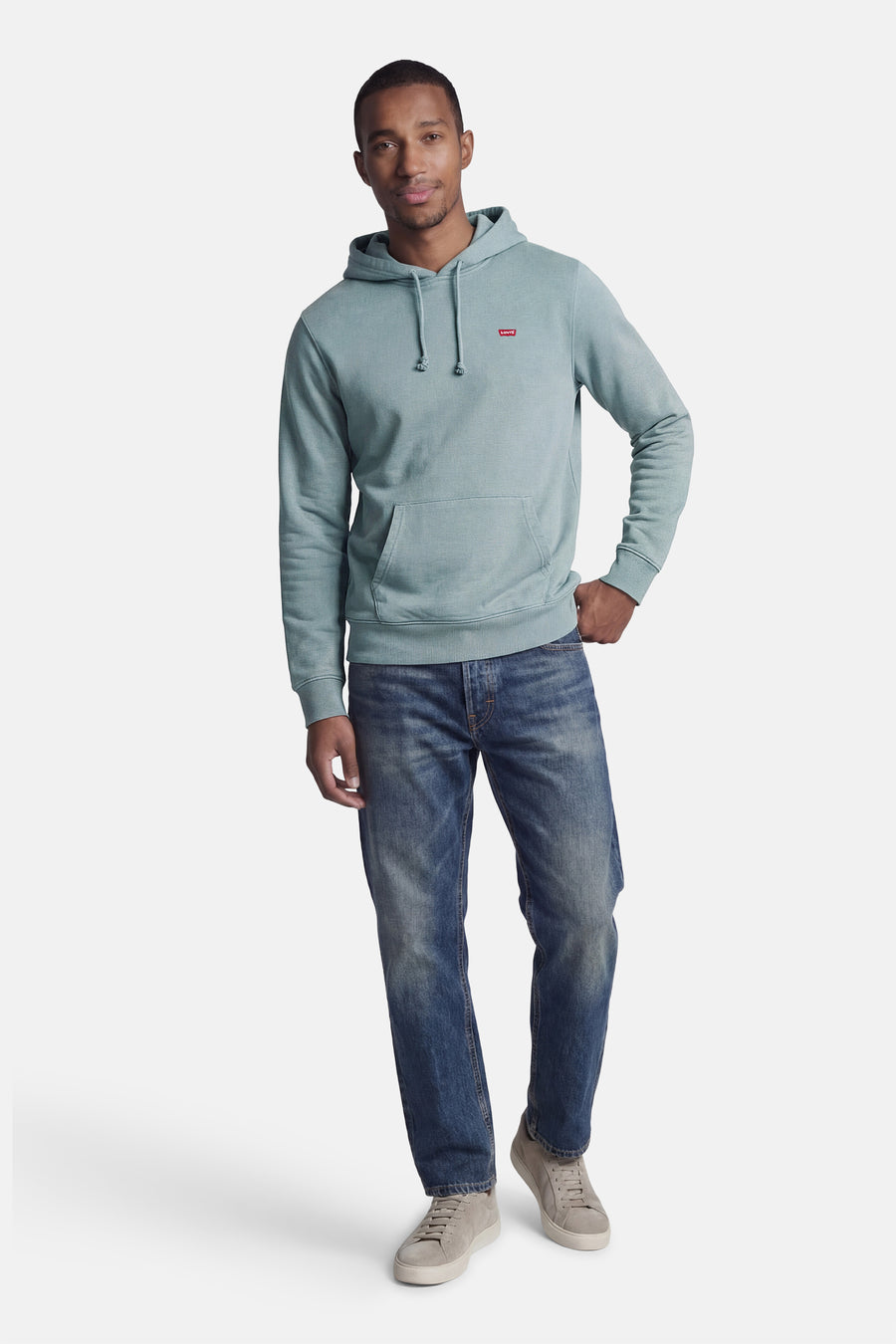 Blauwe sweater met kap van Levi's, met trekkoorden en een buidelzak, gecombineerd met blauwe jeans en grijze sneakers.
