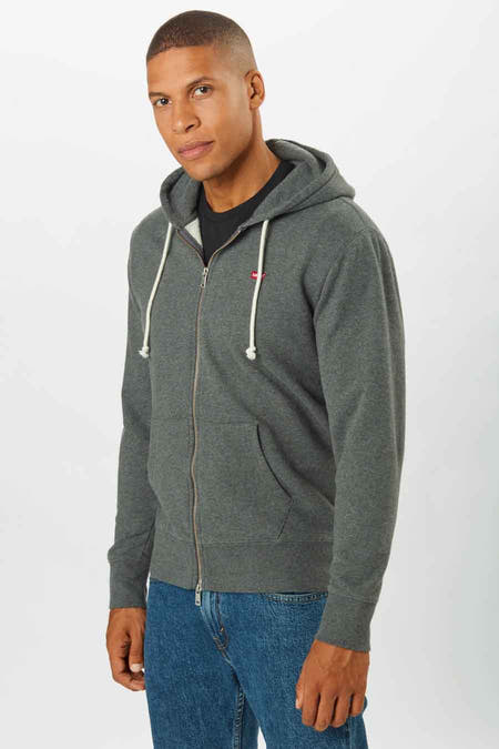 Grijs vest van Levi's, met rits en capuchon, gedragen over een zwart shirt en blauwe jeans.