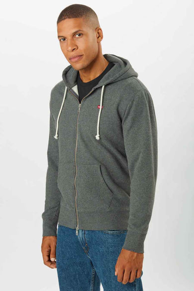 Grijs vest van Levi's, met rits en capuchon, gedragen over een zwart shirt en blauwe jeans.