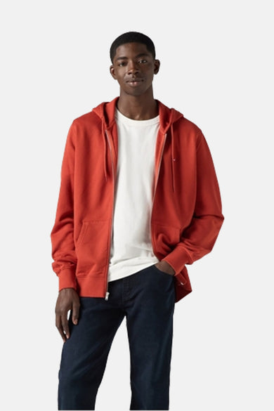 Rode sweater met kap van Levi's, gedragen over een wit T-shirt en donkerblauwe jeans.
