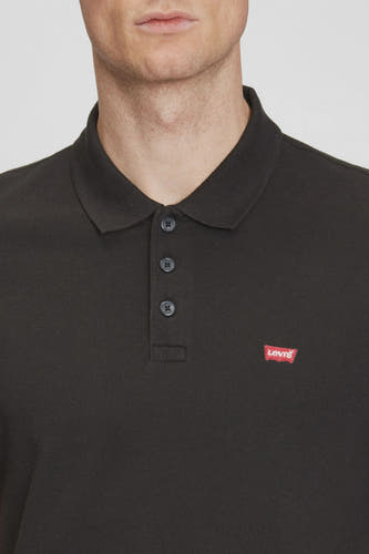 Zwarte polo met korte mouwen van Levi's, met een rode merkbadge op de borst.

