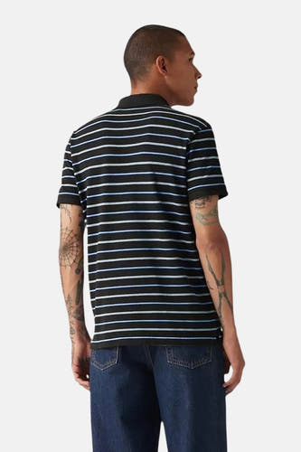 Blauw gestreepte polo met korte mouwen van Levi's, achterkant, gecombineerd met donkere jeans en tatoeages op de armen.