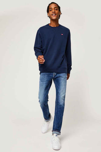 Blauwe sweater van Levi's®, gedragen met jeans en witte sneakers.