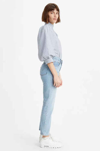 Lichtblauwe straight jeans van Levi's, met een hoge taille en gedragen met een gestreept overhemd en witte sneakers.
