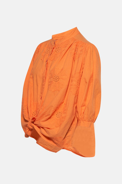 Chemise orange à manches longues de Terra di Siena, avec des motifs floraux brodés et un détail de boutons.