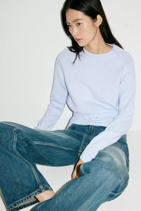 Lichtblauwe ronde hals trui van MANGO, fijn gebreid, met riemdetail, gedragen met blauwe jeans, lifestyle shot