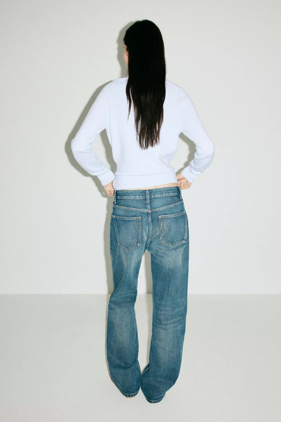 Blauwe ronde-hals trui van MANGO, achterzijde, met lange mouwen en strakke pasvorm, gedragen met blauwe flared jeans.
